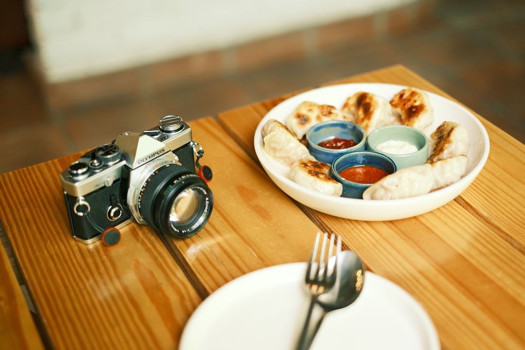 Close up of a vintage film camera and lens on a wooden table