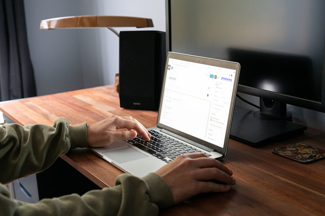 Laptop with photo editing software open on a wooden desk with coffee cup